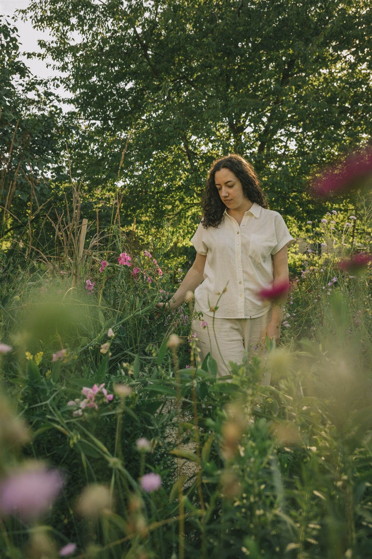 Janine Regez-Renolds beim Kräutersammeln zwischen blühenden Wildpflanzen